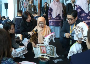 Rina Rahmayanti, S.Pd pemilik Rinara Batik sekaligus Local Hero PLN UID Banten, memandu para delegasi internasional mencoba teknik dasar membatik menggunakan canting.