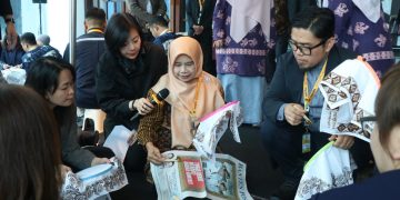 Rina Rahmayanti, S.Pd pemilik Rinara Batik sekaligus Local Hero PLN UID Banten, memandu para delegasi internasional mencoba teknik dasar membatik menggunakan canting.