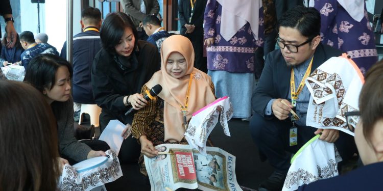 Rina Rahmayanti, S.Pd pemilik Rinara Batik sekaligus Local Hero PLN UID Banten, memandu para delegasi internasional mencoba teknik dasar membatik menggunakan canting.